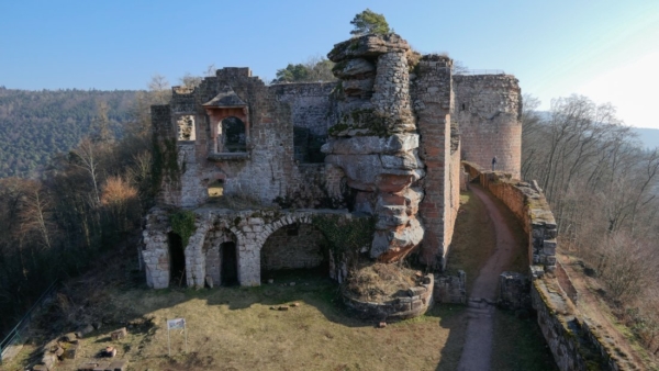 Links: Westgiebel des nach 1469 errichteten Wohnbaus. Die Westmauer war bis ins 19. Jh. noch höher und verfügte über ein heute verschwundenes Fenster über dem Erker. Im Erdgeschos befanden sich die Funktionsräume, wie die Küche, die Schmiede, die Wohnung des Burgverwalters, das Archiv und Lagerräume. Der Felsturm war früher ummandelt, die unteren Steinlagen sind noch vorhanden. Rechts sperrte ein Tor den Zugang aus der Vorburg in den Südzwinger.