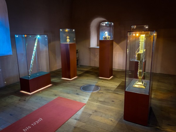 Zu Beginn des staufischen Zeitalters 1125 wurde der Trifels Verwahrort der Reichskleinodien. Im Hauptturm werden Nachbildungen derselben präsentiert. Die Reichskleinodien und -insignien galten als der bedeutendste Schatz des deutschen Mittelalters und waren für die Legitimation der Könige als rechtmäßige Herrscher von überragender Bedeutung und Symbolkraft. Zu Beginn des staufischen Zeitalters wurde der Trifels Verwahrort. Im Hauptturm werden Nachbildungen der bekanntesten Reichskleinodien präsentiert. Die Originale befinden sich in der Schatzkammer der Wiener Hofburg aufbewahrt. Burg Trifels nahm als Aufbewahrungsort der Reichskleinodien zur Staufzeit eine herausragende Rolle ein.
