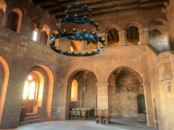 Der sog. "Kaisersaal" reicht über zwei Geschosse. Über der Halle verläuft eine umlaufende Empore mit pfeilergestützten Bögen auf der Südseite und Trippelarkaden. Die Innenwände des Palas bestehen aus großen Quadern, die dem mittelalterlich Erscheinungsbild nachempfunden sein sollen. Eine Doppelarkade führt zum Hauptturm. Zweigeschossiger Kaisersaal im Palas des Trifels