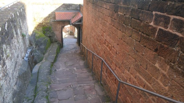 Ab dem unteren Burgtor führt eine neue Treppe hinauf in die Oberburg. Ungefähr auf halber Strecke befindet sich ein weiteres großes Rundbogentor. Die über 4 m hohe Ostwand (rechts) mit ihrem hammerrechten Kleinquadermauerwerk in durchlaufenden Schichten ist nur noch zu einem Drittel ihrer Höhe spätmittelalterlich. Treppenaufgang zur Oberburg