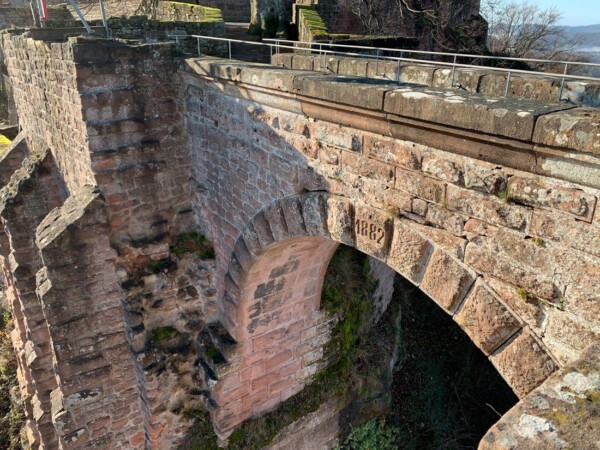 Der stauferzeitliche Brunnenturm steht nordƶstlich auĆerhalb der Burganlage und ist mit dieser durch eine 1882 inschriftlich errichtete steinerne Bogenbrücke verbunden. Zur Stauferzeit war die Brücke aus Holz gefertigt. Eine steinerne Rundbogenbrücke verbindet den Brunnenturm mit dem nƶrdlichen Burghof von Burg Trifels