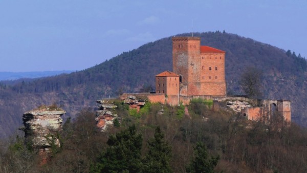 Der Trifels erhebt sich auf einem 150m lagen, schmalen Felsriff, das die Spitze des knapp 500 Meter hohen Sonnenbergs bildet. Von der nahegelegenen Burg Scharfenberg kann man mit einem Teleobjektiv ein schönes Bild der Gesamtanlage aus Südosten machen. Den schönsten Blick auf die Gesamtanlage hat man von der nahegelegenen Burg Scharfenberg aus