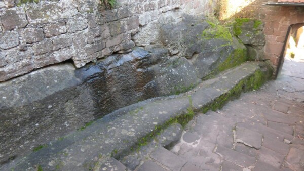 Auf der Westseite des Torweges ist eine Rinne in den Fels eingemeiĆelt, durch die das abflieĆende Wasser in den unteren Wasserbecken gesammelt werden konnte. Wasserrinne auf der Westseite des Treppenwegs zur Speisung der zwei unteren Felsbecken.