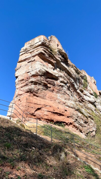 Kernfels mit suedlicher Oberburg von unten. Mehrere Balkenlöcher an der glatt abgearbeiteten Südseite des Kernfelsens belegt eine anlehnende Bebauung. Kernfels mit südlicher Oberburg von unten
