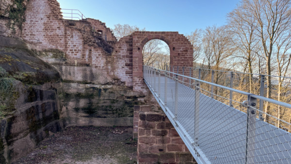 Die spätmittelalterliche Brücke über den Halsgraben dürfte nicht ohne eine im tornahen Bereich als Zugbrücke ausgeprägte SIcherung zum Tor geführt haben. Das Äußere Burgtor wurde in der 2010er Dekade völlig neu errichtet ohne aber die Details dieser Zugbrücke zu berücksichtigen. Die hochrechteckigen Löcher am Torbogen deuten möglicherweise die Kettenführung einer Zugbrücke an. Es fehlt aber eine Aussparung für die bündige Aufnahme der Zugbrücke. Auf der Innenseite des Tores sind überhaupt keine Anhaltspunkte über eine Zugbrück zu finden. Heute betritt man die Burg auf einem neuzeitlichen metallenen Steg. Neuzeitlicher Metallsteg über jüngeren Halsgraben