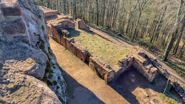 Auf der Westseite des Burghofes standen einst mehrer Gebäude, von denen das sog. "Steinerne Haus" in Fundamentresten noch erhalten ist. Dieses Haus war unterkellert, der Treppenabgang in das Tonnengewölbe befand sich auf der Nordseite (Bild rechts hinter Quermauer). Steinernes Haus an der Westseite der Unterburg