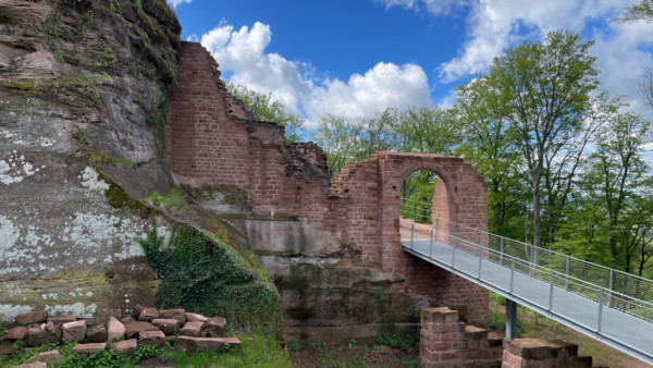 Der sich östlich (Abb. links) an das Burgtor anschließende Mauerzug, der heute noch etwa 7,5m Höhe misst, wird im Schrifttum als Schildmauer klassifiziert. Restaurierte Schildmauer zwischen Burgtor und Kernfels