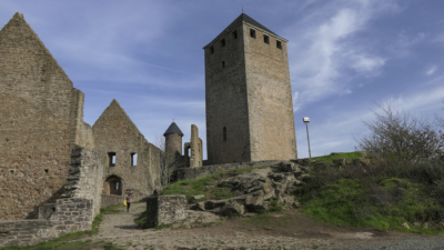 Zentral, und weithin als Machtsymbol erkennbar, steht der 33 Meter hohe Bergfried aus dem 12. Jahrhundert. Kernburg aus Westen